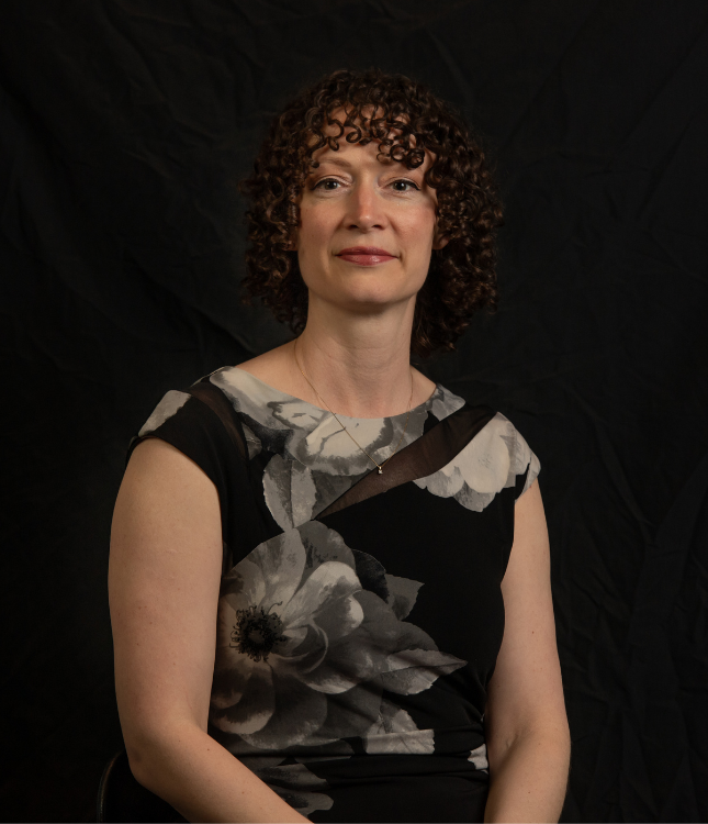 "Woman posing for a headshot photo with a black background"