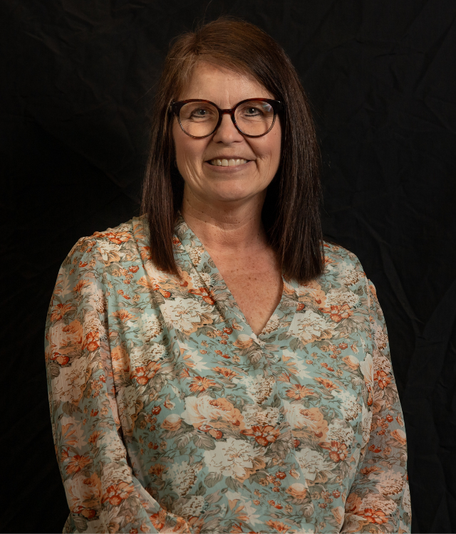 "Woman posing for a headshot photo with a black background"