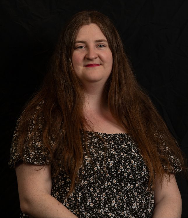 "Woman posing for a headshot photo with a black background"